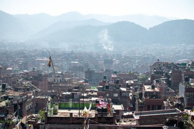Bhaktapur, Kathmandu, Nepal - December 23, 2019: Cityscape view from a roof top over brick houses and temples with unidentified people, their gardens, plants and laundry on the roofs on December 23, 2019 in Bhaktapur, Kathmandu, Nepal clipart