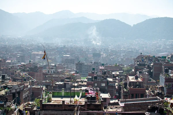 Bhaktapur, Katmandu, Nepal - 23 Aralık 2019: Tuğla evler ve kimliği belirlenemeyen insanlarla dolu çatılardan, bahçelerinden, bitkilerinden ve çamaşırlarından oluşan şehir manzarası 23 Aralık 2019 'da Bhaktapur, Katmandu, Nepal