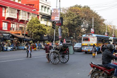 Kolkata, Hindistan - 1 Şubat 2020: Kimliği belirsiz bir adam ve kimliği belirsiz bir kadın, 1 Aralık 2020 'de Kolkata, Hindistan' da kimliği belirsiz yayaların yanında otobüs ve araçlarla karşıdan karşıya geçiyor.