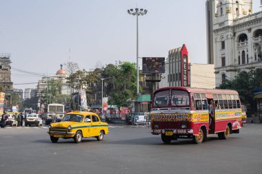 Kolkata, Hindistan - 1 Şubat 2020: 1 Şubat 2020 'de Kolkata, Hindistan' da otobüsler ve arabalar trafiğin içinden geçerken, kimliği belirsiz kişiler kavşakta yürüyor