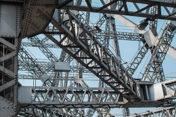 Looking up at metal beams and triangular shapes of Howrah bridge in Kolkata, India