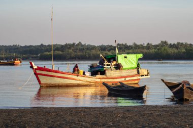 Chaung Thar, Myanmar - 26 Aralık 2019: 26 Aralık 2019 'da Chaung Thar, Myanmar' da günbatımında yanan nehrin kıyısındaki geleneksel ahşap botlar