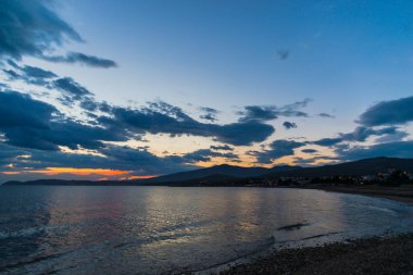 Çakıl taşları ve gün batımı arka plan ile deniz kıyısı
