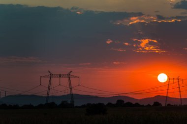 kırmızı güneş ve gökyüzünde, elektrik direkleri iletim günbatımı