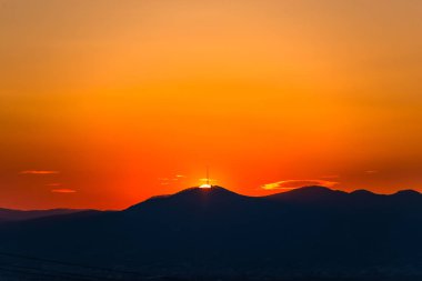 Dağlarda parlak turuncu gün batımı, doğal manzara.
