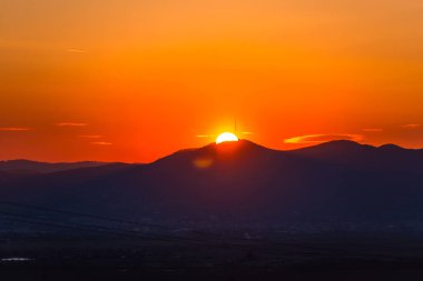 Dağlarda parlak turuncu gün batımı, doğal manzara.