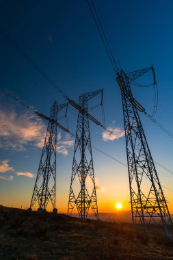 turuncu günbatımı gökyüzü ve iletim elektrik direkleri kırsal alandaki 