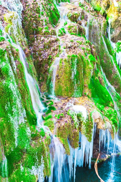 融解凍結氷柱と緑の苔草滝 — ストック写真