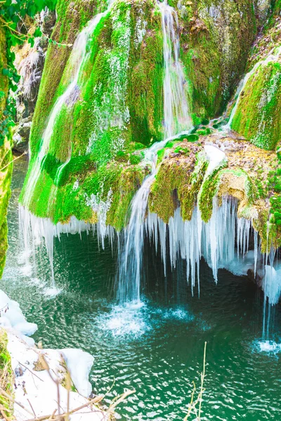 融解凍結氷柱と緑の苔草滝 — ストック写真