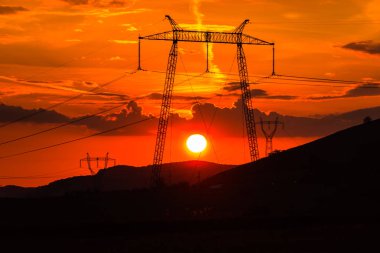 parlak kırmızı günbatımı gökyüzü ve elektrik direkleri