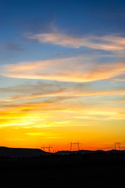 turuncu günbatımı gökyüzü ve iletim direkleri 