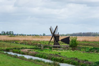 Alanları ve nehir ile küçük ahşap yel değirmeni