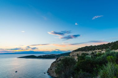 bulutlar, deniz suyu ve ada ile görkemli mavi gökyüzü 