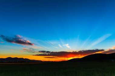 görkemli turuncu günbatımı veya gündoğumu gökyüzü ve iletim elektrik direkleri