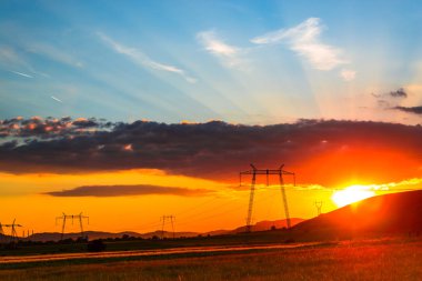 gökyüzü ve iletim elektrik direkleri güneşte ile görkemli turuncu günbatımı
