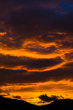 görkemli turuncu kırmızı günbatımı gökyüzü bulutlu, dikey görüntü