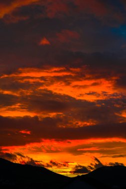 görkemli turuncu kırmızı günbatımı gökyüzü bulutlu, dikey görüntü