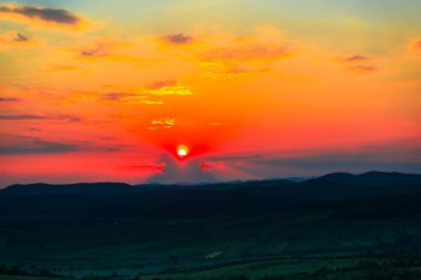 görkemli turuncu kırmızı günbatımı gökyüzü ve tepeler 