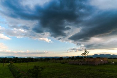 Bulutlu gökyüzü ile sahada gün batımı