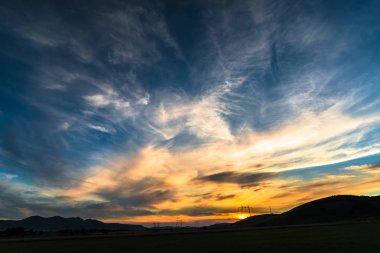 bulutların üzerinde manzara çayır alan Hills ile günbatımı gökyüzü