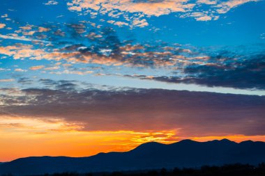 akşam günbatımı gökyüzü ve dağlar siluet 