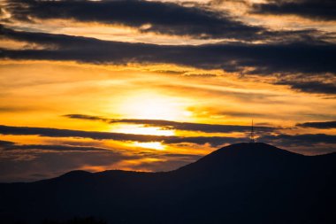 Gün batımı arka planı olan tepeler
