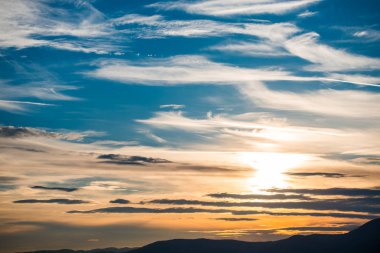 Gün batımı arka planı olan tepeler