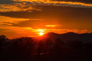 Güneş ufukta günbatımı gökyüzü ve dağlar siluet  