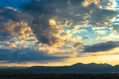 Ufukta bulutlar ve tepeler manzara ile bulutlu gökyüzü günbatımı 