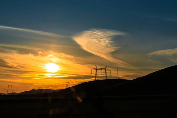 Veld Met Elektriciteit Palen Bij Zonsondergang — Stockfoto