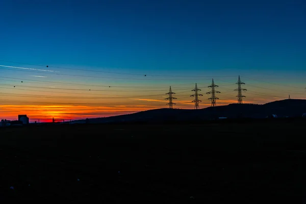 日落时有电线杆的田野 — 图库照片