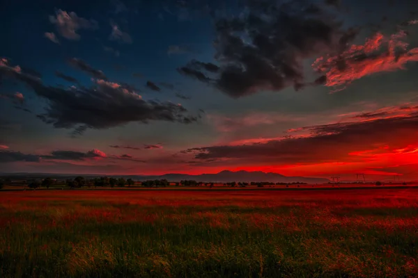 Kırmızı günbatımı gökyüzü ufukta bulutlar ve tepeler manzara ile 