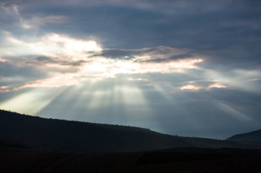 Hills bulutlu gökyüzü ve güneş ışınları, doğal arka plan ile.