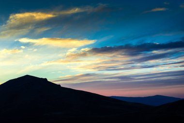 Günbatımı gökyüzü arka plan ile Dağları