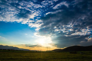 bulutlu akşam günbatımı, gökyüzü ve tepeler