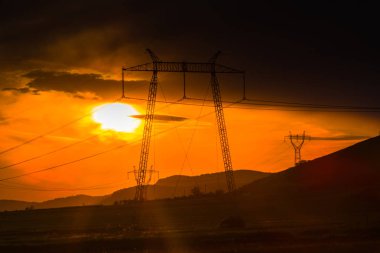 günbatımı güneş gökyüzünde, alandaki elektrik direkleri 