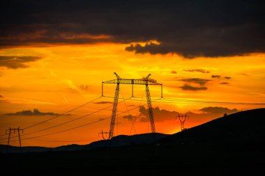parlak kırmızı günbatımı gökyüzü ve elektrik direkleri