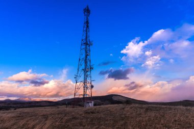 Gün batımı gökyüzü arka plan üzerinde elektrik direkleri ile Alan
