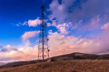 Gün batımı gökyüzü arka plan üzerinde elektrik direkleri ile Alan