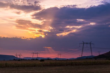 Görkemli Mor günbatımı gökyüzü ve elektrik direkleri