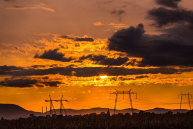 görkemli turuncu günbatımı gökyüzü ve elektrik direkleri 