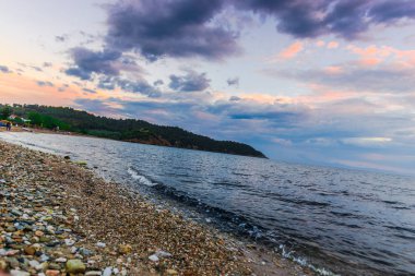 Günbatımında güneş ve renkli bulutlar gizleme ile boş deniz kıyısı