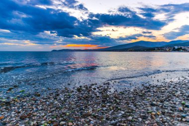Günbatımında güneş ve renkli bulutlar gizleme ile boş deniz kıyısı