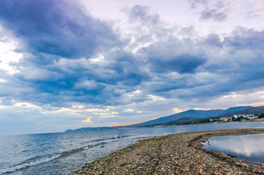 Günbatımında güneş ve renkli bulutlar gizleme ile boş deniz kıyısı