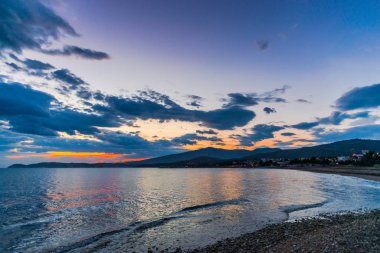 Günbatımında güneş ve renkli bulutlar gizleme ile boş deniz kıyısı