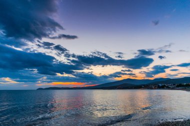 Günbatımında güneş ve renkli bulutlar gizleme ile boş deniz kıyısı