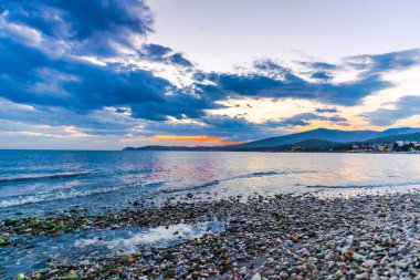 Günbatımında güneş ve renkli bulutlar gizleme ile boş deniz kıyısı