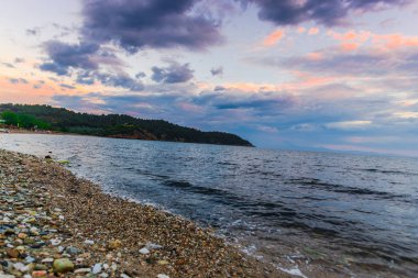 Günbatımında güneş ve renkli bulutlar gizleme ile boş deniz kıyısı