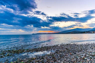 Günbatımında güneş ve renkli bulutlar gizleme ile boş deniz kıyısı