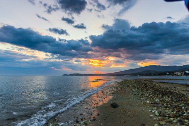 Günbatımında güneş ve renkli bulutlar gizleme ile boş deniz kıyısı